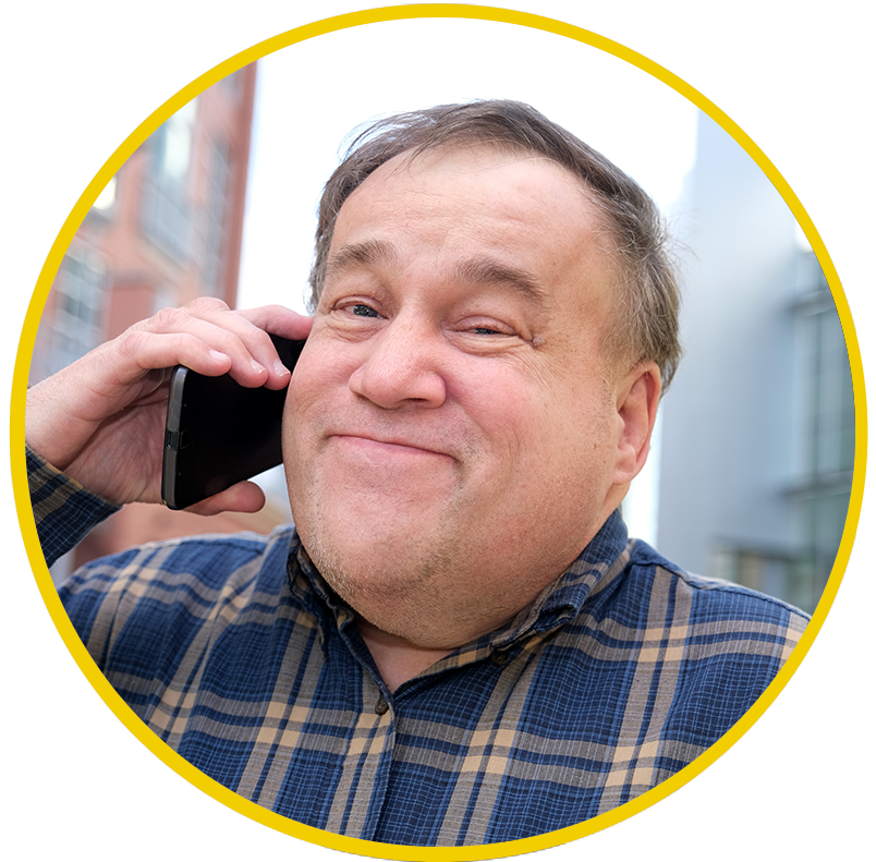 A man with autism smiling on the phone.